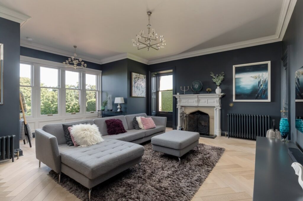 Image of Living Room, showing a navy blue room with a gray sofa from Ellisons’ past prime and super prime properties projects in Scotland.