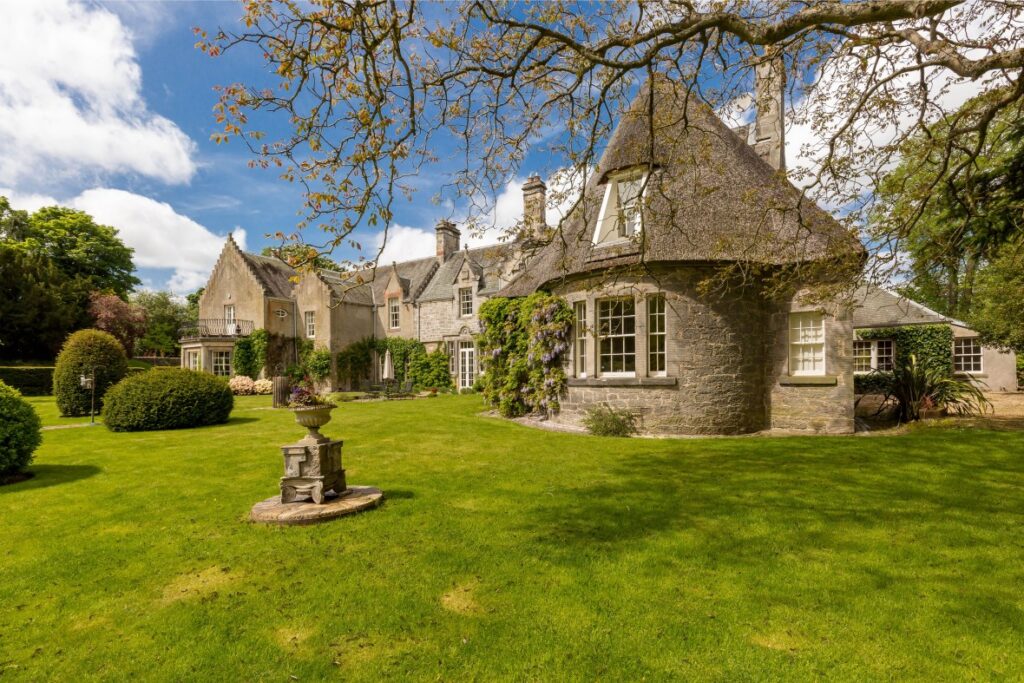 Image of exterior of house, showing a garden from Ellisons’ past prime and super prime properties projects in Scotland.